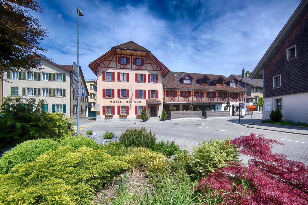 un grand bâtiment sur le côté d'une rue dans l'établissement Ochsen Lenzburg, à Lenzburg