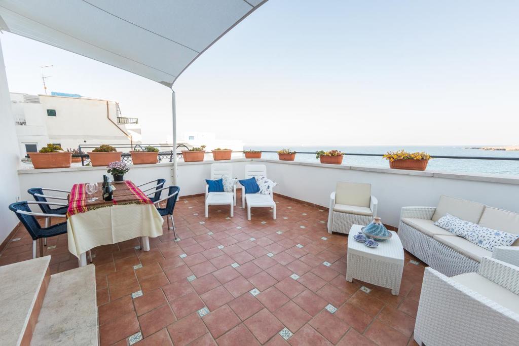 een balkon met een tafel en stoelen en de oceaan bij Le Terrazze Monopoli Puglia in Monopoli