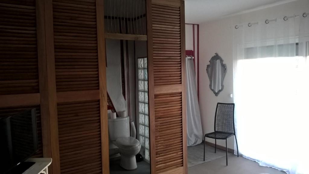 uma casa de banho com WC e um armário de madeira em Chambre en Havre de paix em Panazol