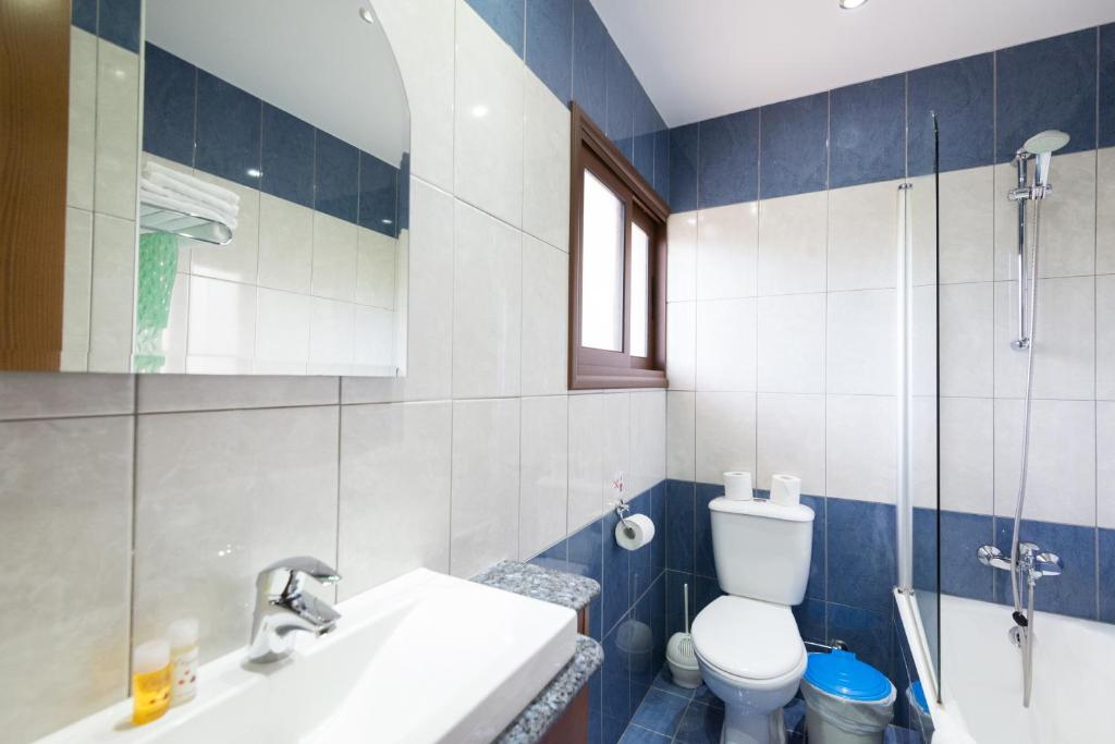 a bathroom with a sink and a toilet and a shower at Loutsiana Deluxe Apts in Ayia Napa