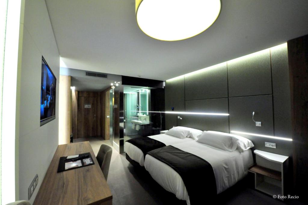 A bed or beds in a room at Hotel & Spa Ciudad de Binéfar