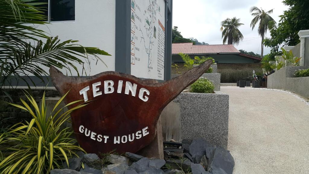 un letrero para una casa de huéspedes frente a una casa en TEBiNG Guest House Taman Negara Malaysia Kuala Tahan en Kuala Tahan