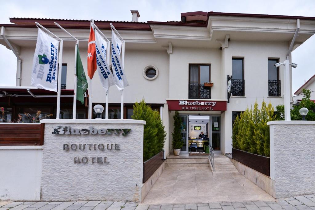 un hotel con banderas frente a un edificio en Blueberry Boutique Hotel, en Fethiye