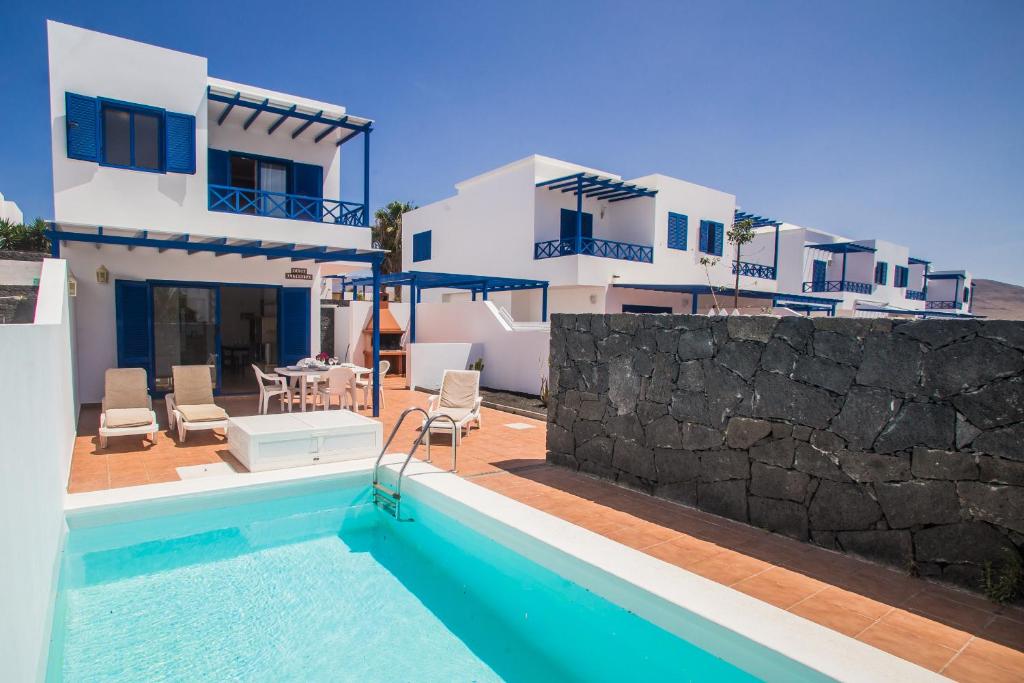 a villa with a swimming pool and a house at Villa Aitonita in Playa Blanca