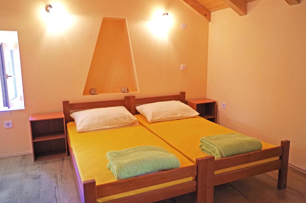 a bedroom with a yellow bed with two towels on it at apartman željana in Vis