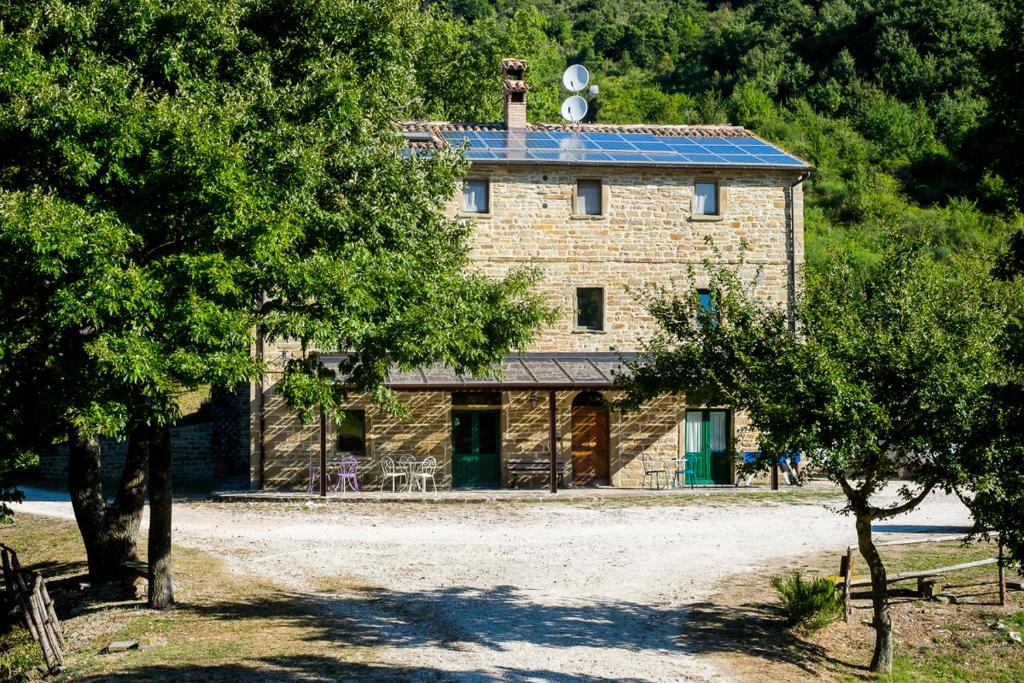 a large building with a tree in front of it at Agriturismo Foglie in Gubbio
