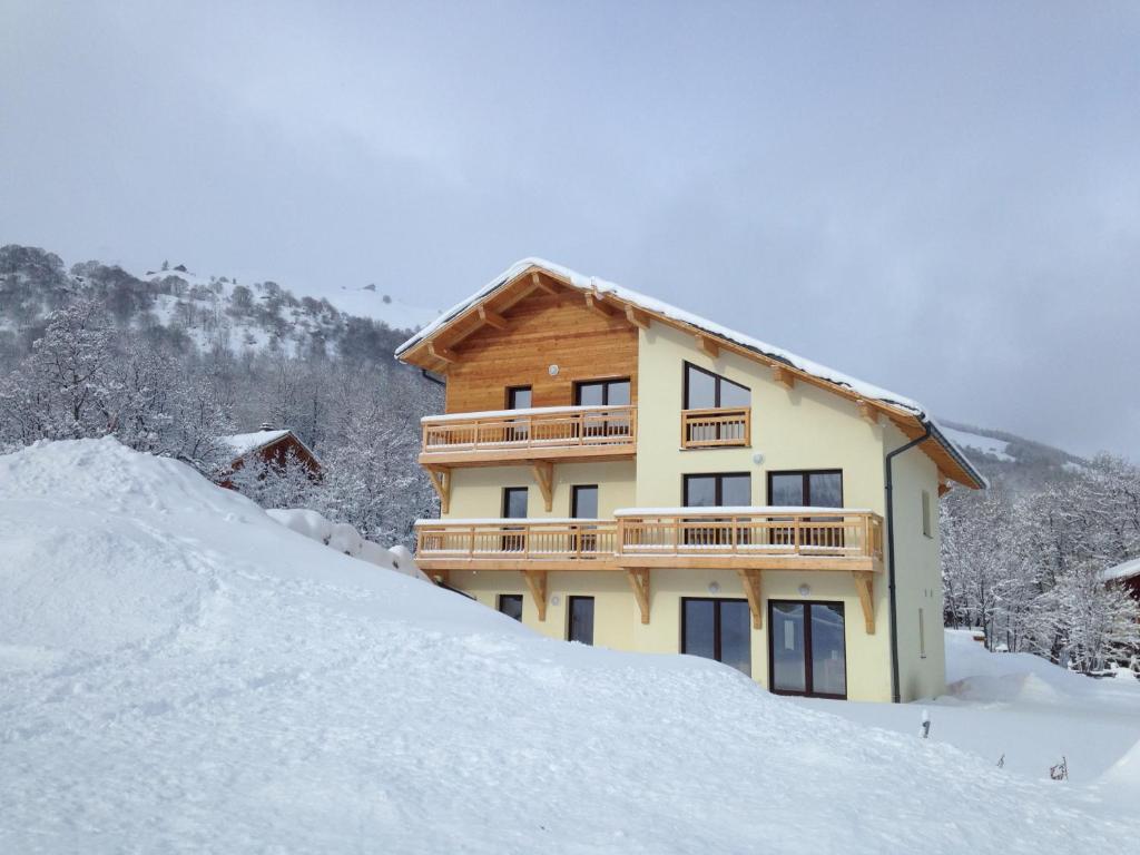 een huis in de sneeuw met een berg sneeuw bij Les Chalets Du Grand Galibier in Valloire