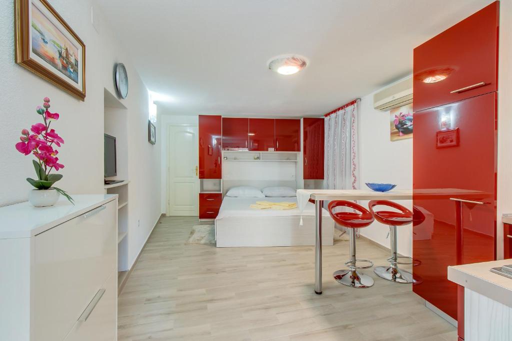 una cucina e un soggiorno con rosso e bianco di Apartments Leila a Mali Lošinj (Lussinpiccolo)