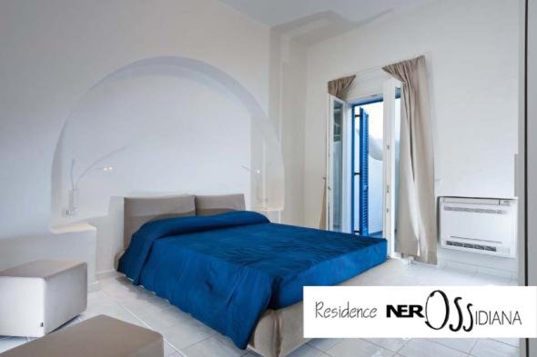 sypialnia z łóżkiem z niebieskim kocem w obiekcie NerOssidiana sul mare di Lipari w mieście Lipari