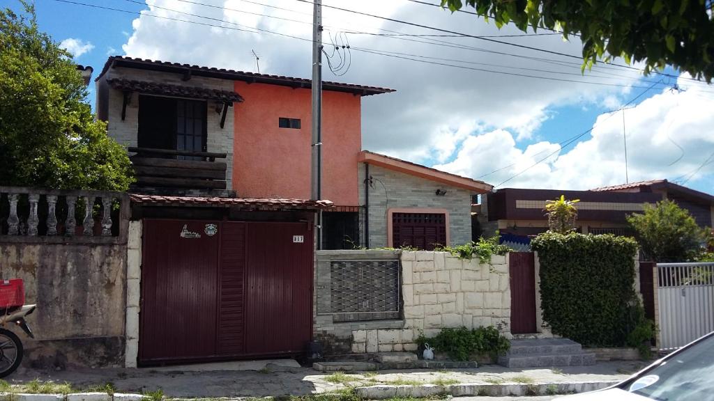 une maison avec des portes rouges et une clôture dans l'établissement Apartamentos Caribe, à João Pessoa
