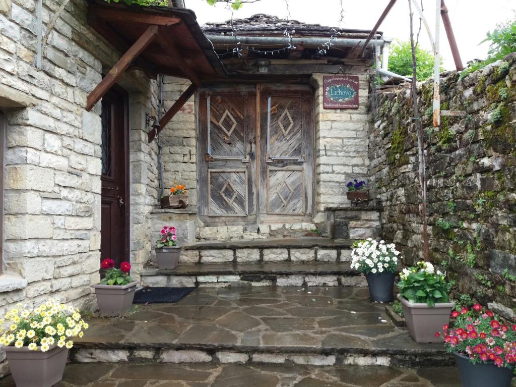 una entrada a una casa de piedra con puerta de madera en Lichovo, en Papigko