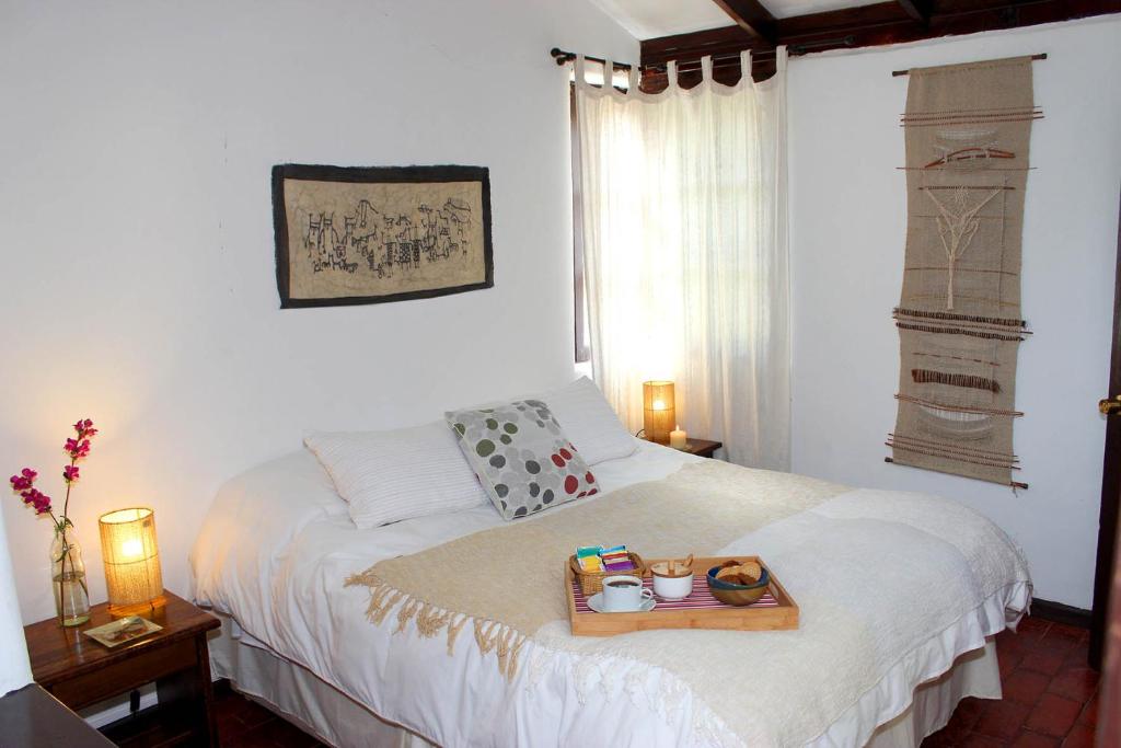 a bedroom with a bed with a tray of food on it at Cabañas El Albaricoque Cochiguaz in El Sanjeado