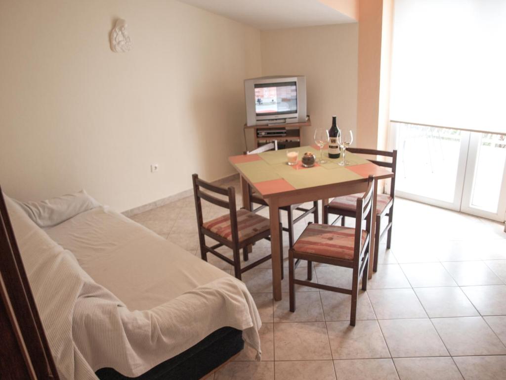 a room with a table and chairs and a bed at Apartment Pletikosic in Kaštela