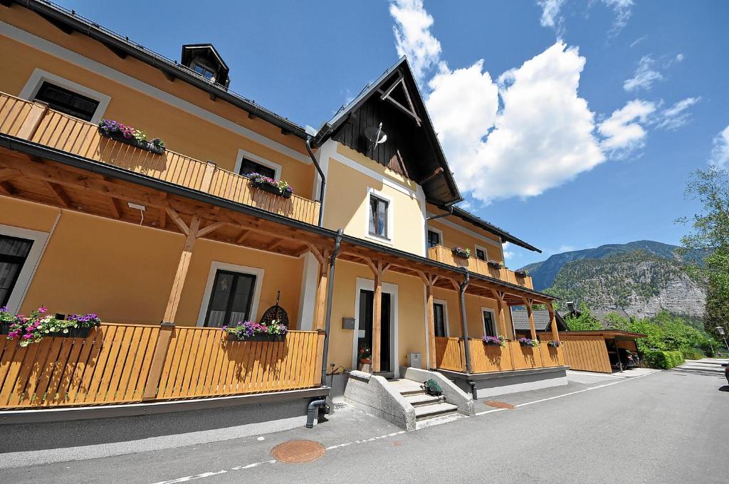 ein Gebäude mit Holzbalkonen und Blumen darauf in der Unterkunft Apartements Wallner in Hallstatt