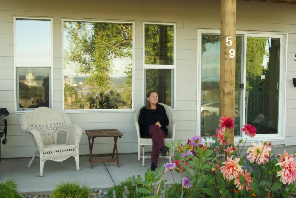 a woman sitting on the front porch of a house at AnnArthur Guest House in Nanaimo