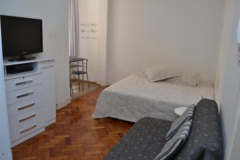 a small bedroom with a bed and a television at Studio Copacabana in Rio de Janeiro