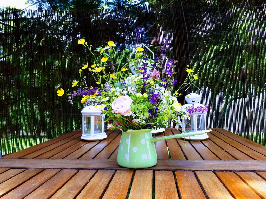 un vase rempli de fleurs sur une table en bois dans l'établissement Apartment Villa Zizzy, à Rakovica