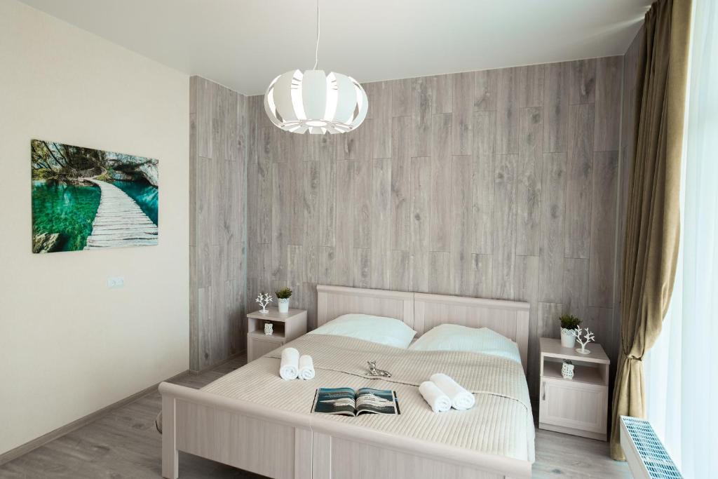 スヴェトロゴルスクにあるSunny Svetlogorsk 13のベッドルーム1室(ベッド1台、タオル2枚、シャンデリア付)