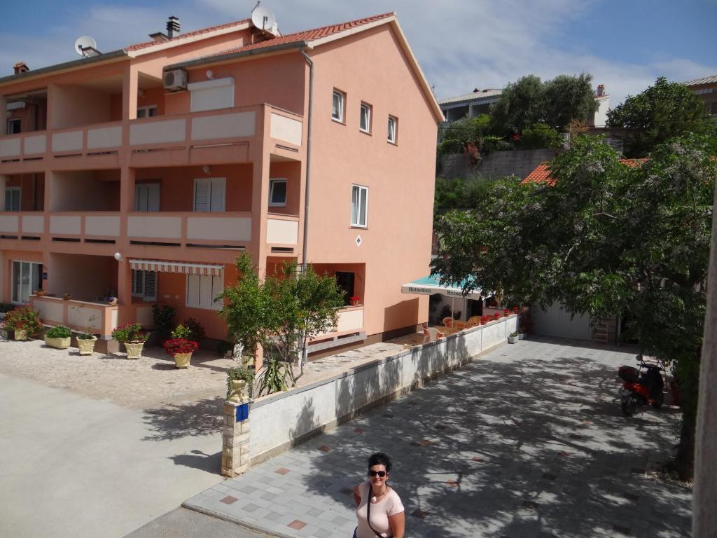 een vrouw die voor een gebouw staat bij Guest house Maria Rosa in Rab