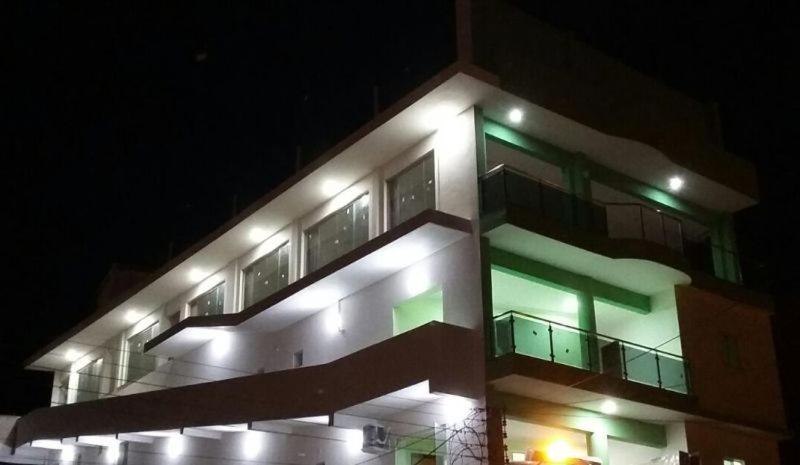 a building with green lights on it at night at Pousada Max in Currais Novos