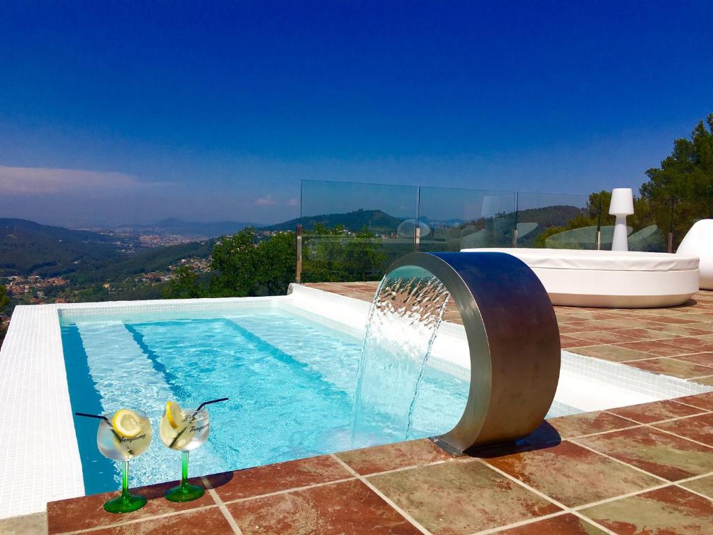 a swimming pool with a water fountain at Petit Mirador in Torrelles de Llobregat