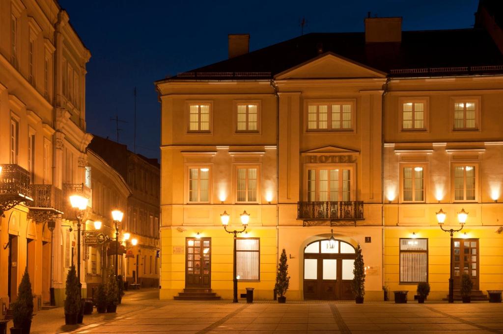 a building with lights on a street at night at Kamienica Szefferów 1848 r. in Piotrków Trybunalski