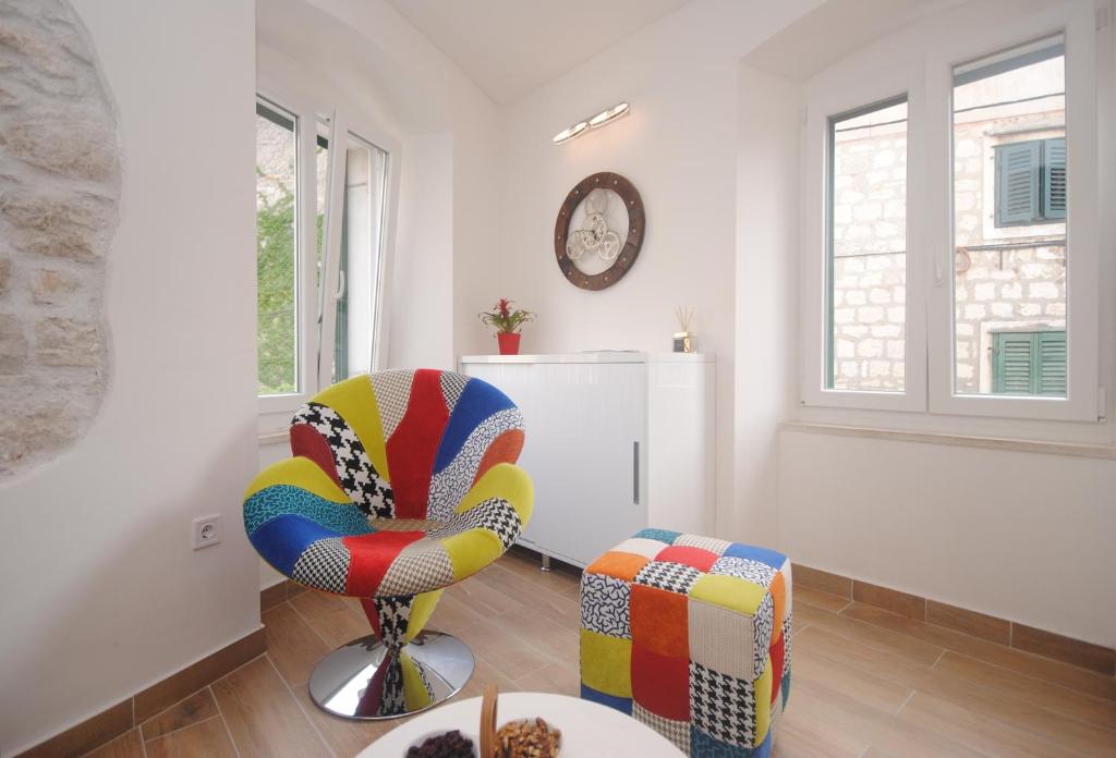 ein Wohnzimmer mit einem farbenfrohen Stuhl und einem Tisch in der Unterkunft Apartments Kogo in Split