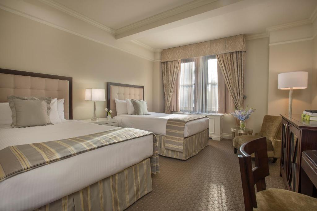 a hotel room with two beds and a window at Warwick New York in New York