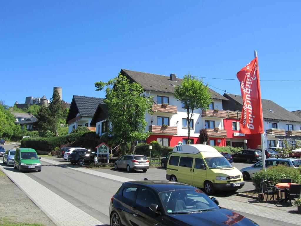 a street with cars parked in front of houses at Land-gut-Hotel zur Burg Nürburg in Nürburg
