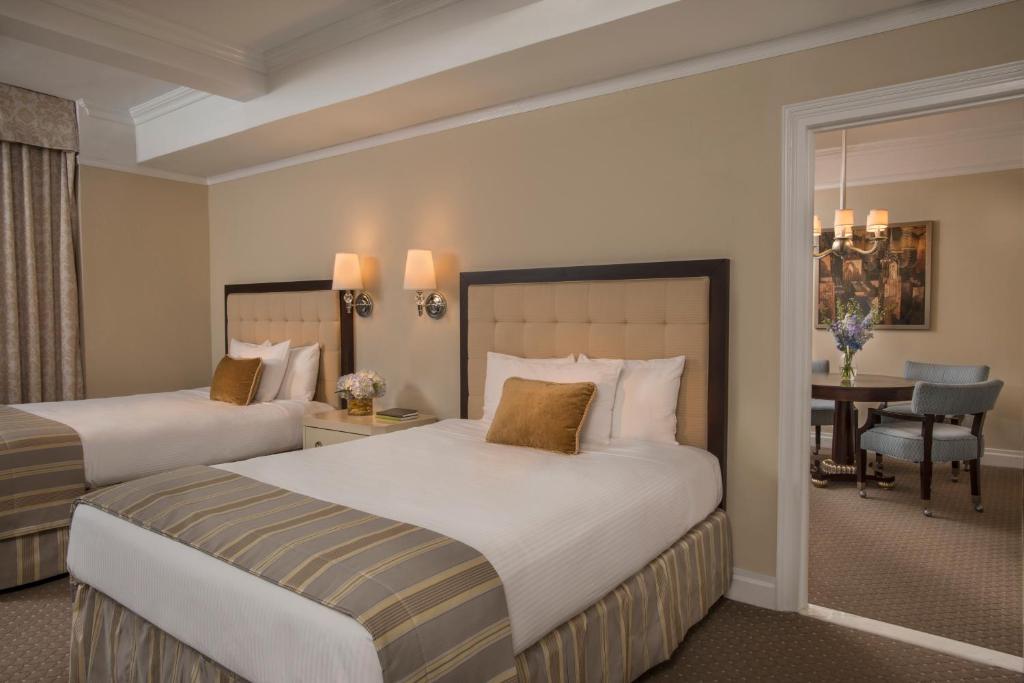 a hotel room with two beds and a dining room at Warwick New York in New York