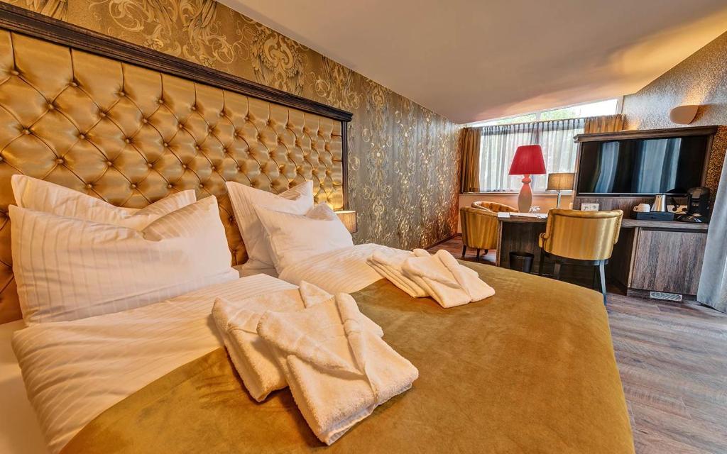 a bedroom with a large bed with towels on it at SPREE Hotel in der Altstadt in Lübbenau