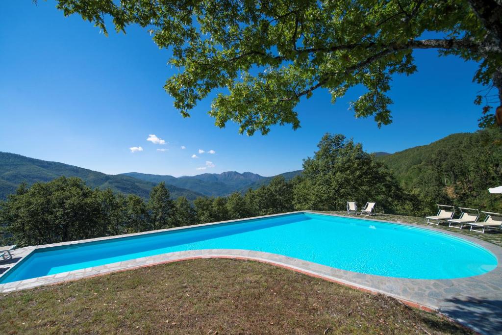 a swimming pool with mountains in the background at Agriturismo Il Gufo in San Marcello Pistoiese