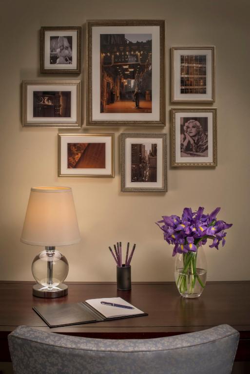 a desk with a lamp and a vase of purple flowers at Warwick New York in New York