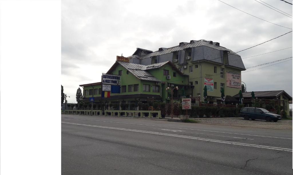 un grande edificio verde sul lato di una strada di Complex Europa L.G a Ploieşti