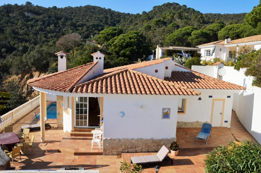 a white house with a roof with a patio at Can Jenny in Tossa de Mar
