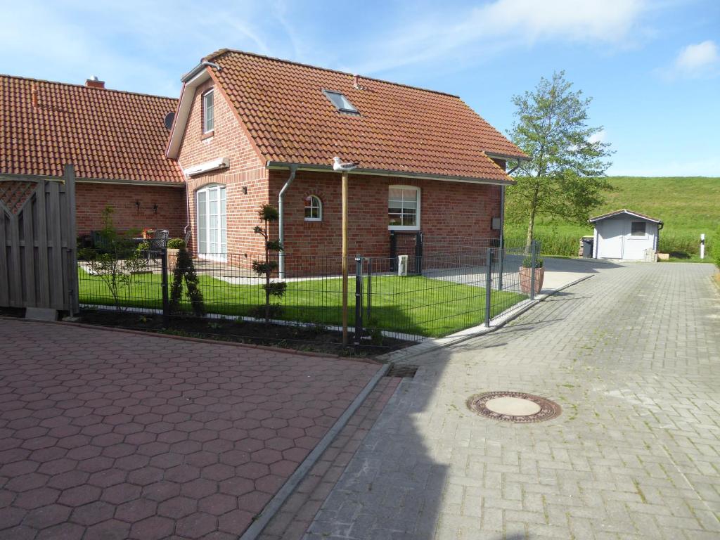 a brick house with a fence in front of it at Skippersin5 in Greetsiel
