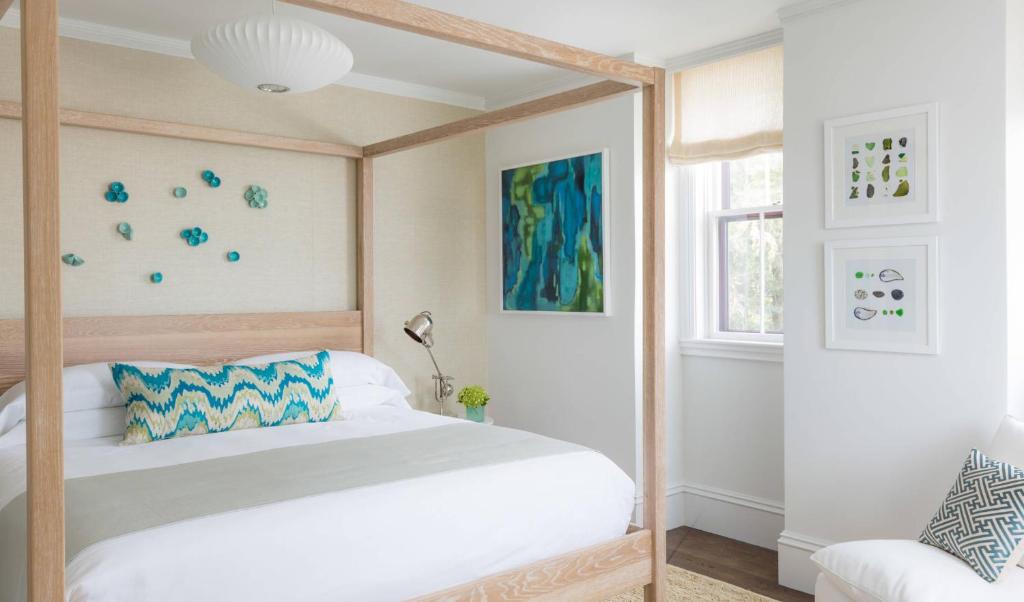 1 dormitorio con cama con dosel y ventana en 21 Broad en Nantucket