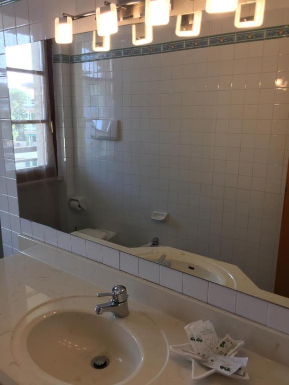 a bathroom with a sink with a mirror and a tub at Residence Alexandra Stay in Sirmione