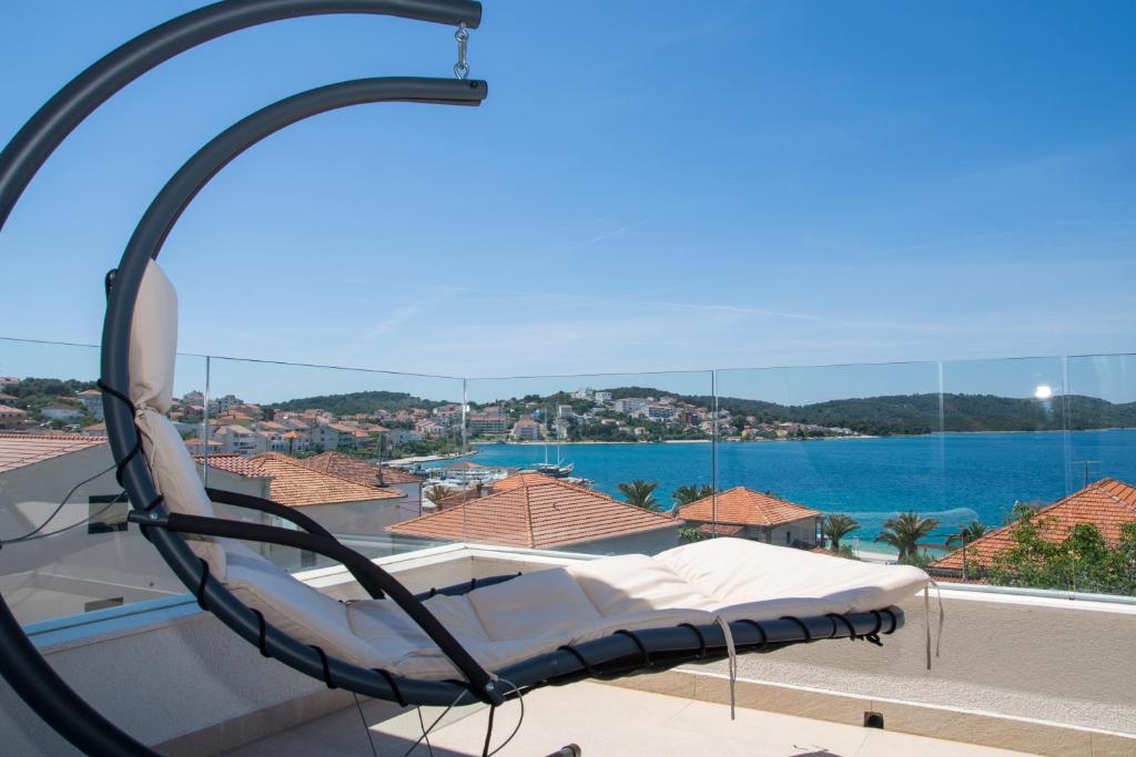 a bed on a balcony with a view of the water at Apartments Soho in Trogir
