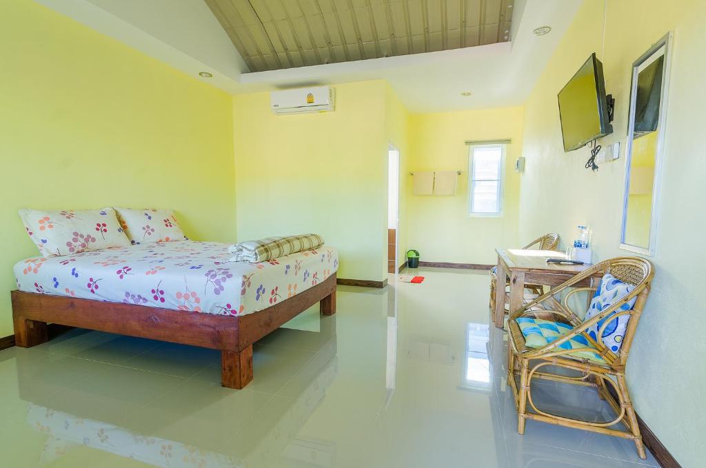 um quarto com uma cama e uma cadeira em Ariya Garden Home em Chumphon