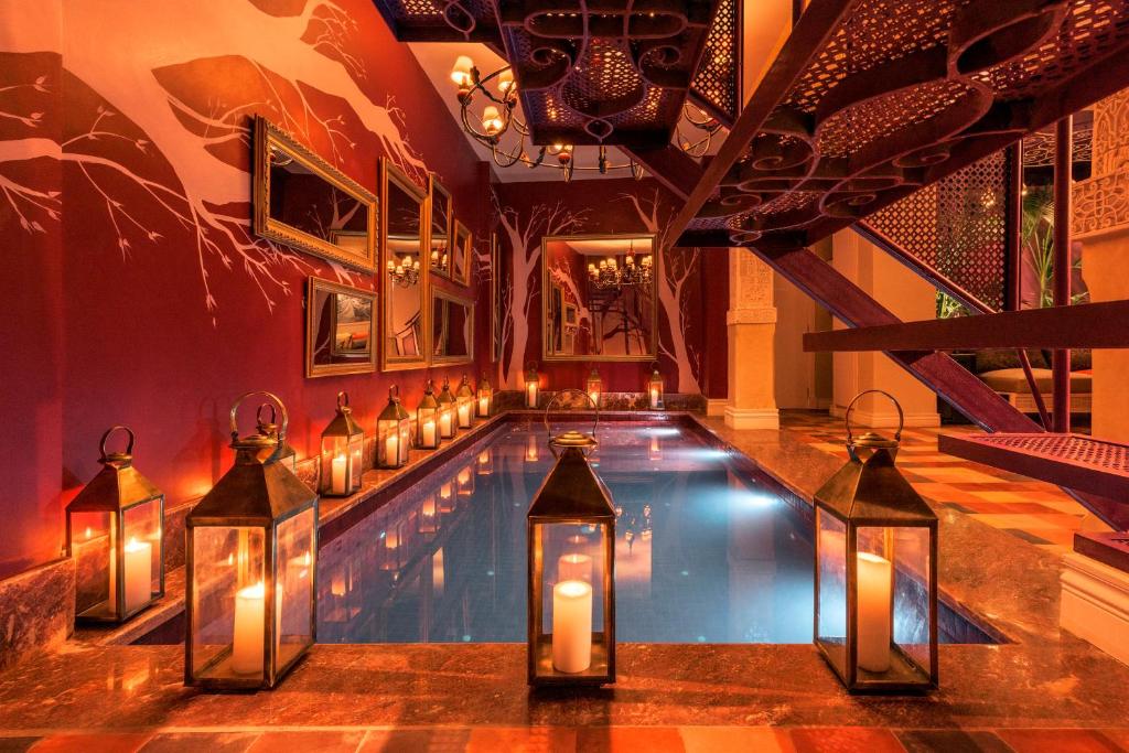 a swimming pool with lanterns and candles in a house at Riad Karmela Princesse in Marrakesh