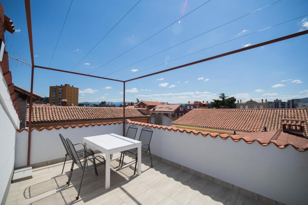 een balkon met een tafel en stoelen op een dak bij Apartment Ana in Koper