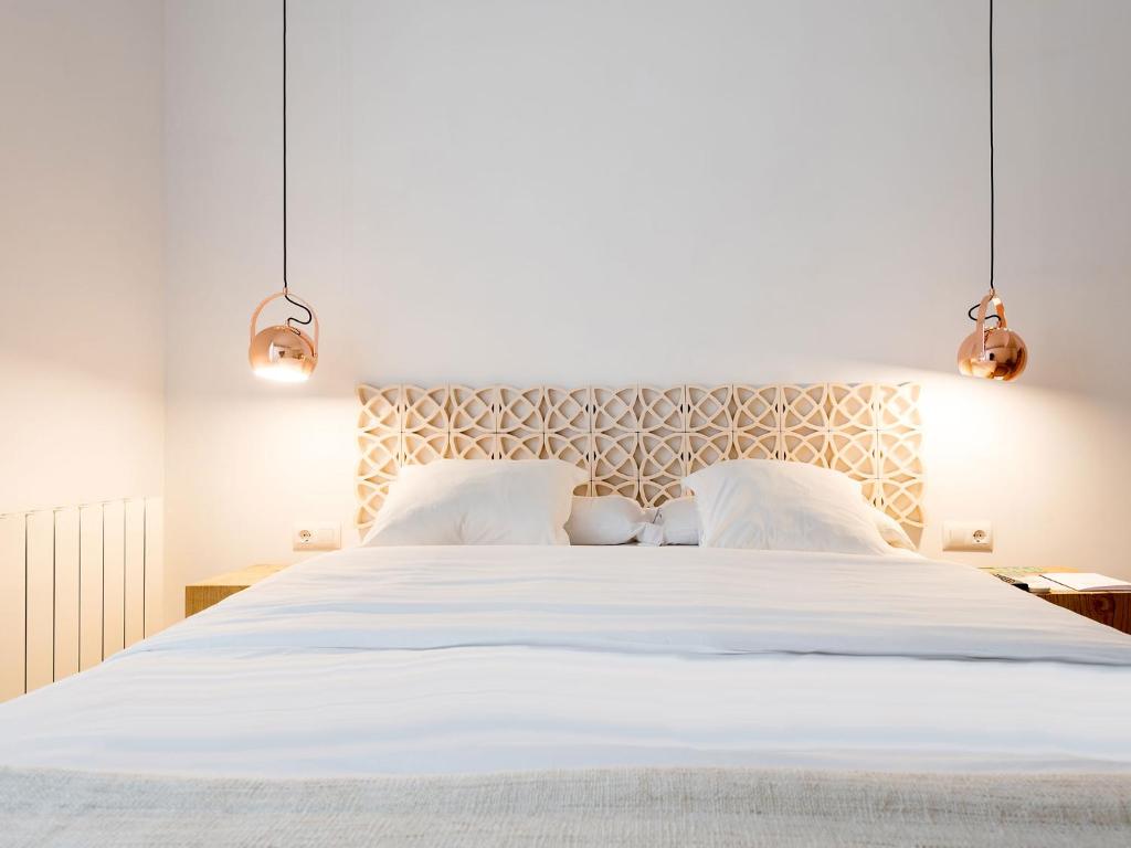 a white bed with a white bedspread and pillows at Bruc & Bruc in Barcelona