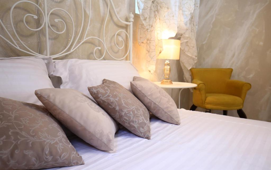 1 dormitorio con 1 cama con almohadas y silla en Luxury Lidija Rooms, en Split
