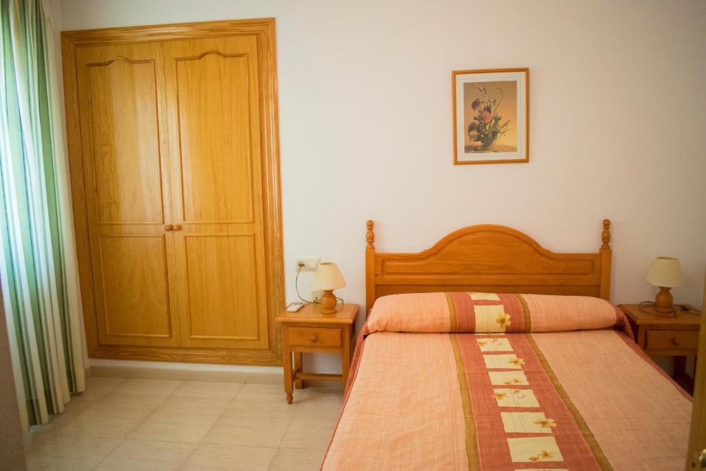 Posteľ alebo postele v izbe v ubytovaní Apartamentos Carmina