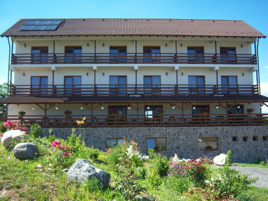 a large building with a balcony on the side of it at La Curtea Porumbaceana in Porumbacu de Sus