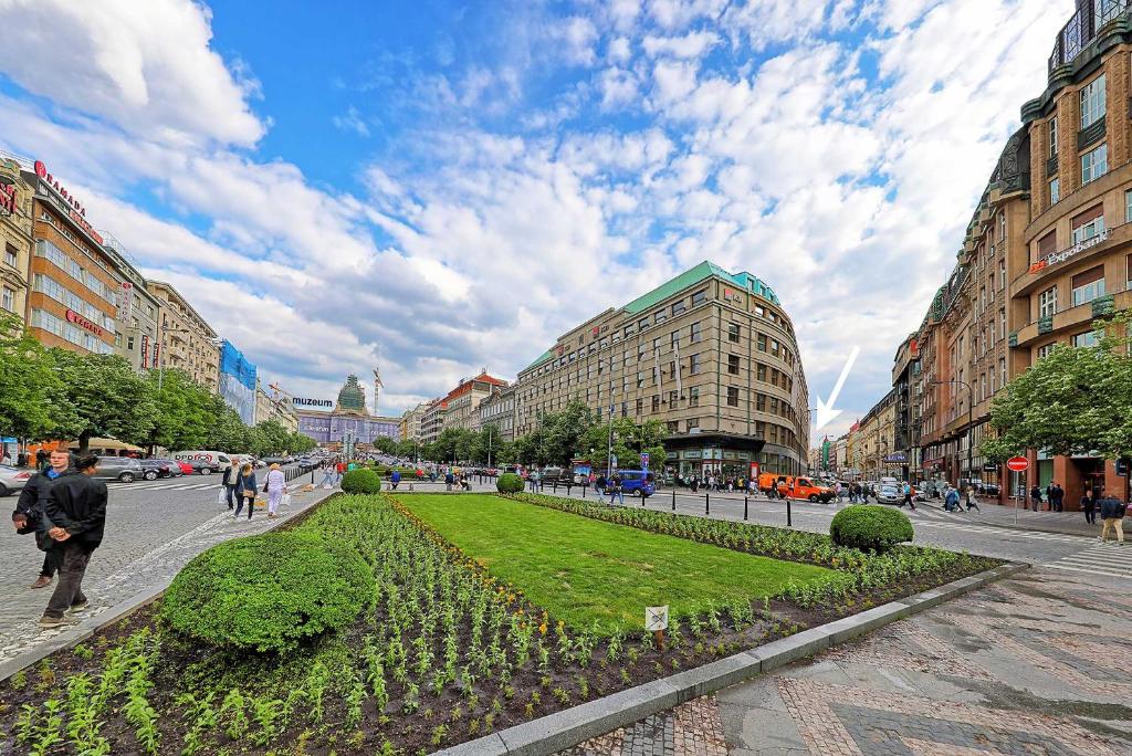 ulica w mieście z budynkami i parkiem w obiekcie Apartments Stepanska 36 w Pradze