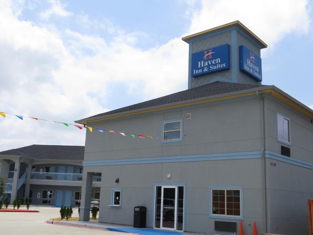 a building with a sign on top of it at Haven Inn & Suites willowbrook in Houston