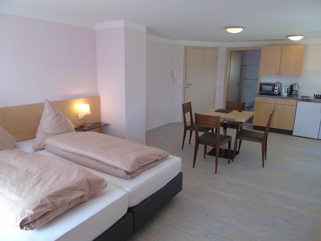 1 dormitorio con cama, mesa y cocina en Wein- Appartements Borth, en Bretzfeld