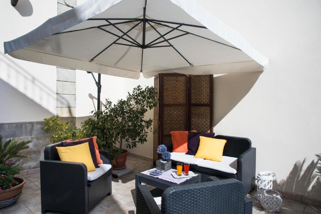 un patio con due sedie e un ombrellone di Le Tre Rose di Giò a Casamassella